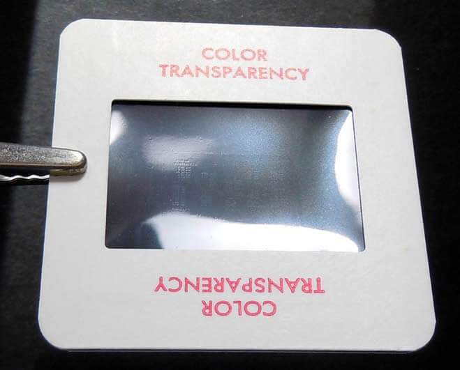 Mounted slide with visible bulge toward the center—film cannot lie perfectly flat